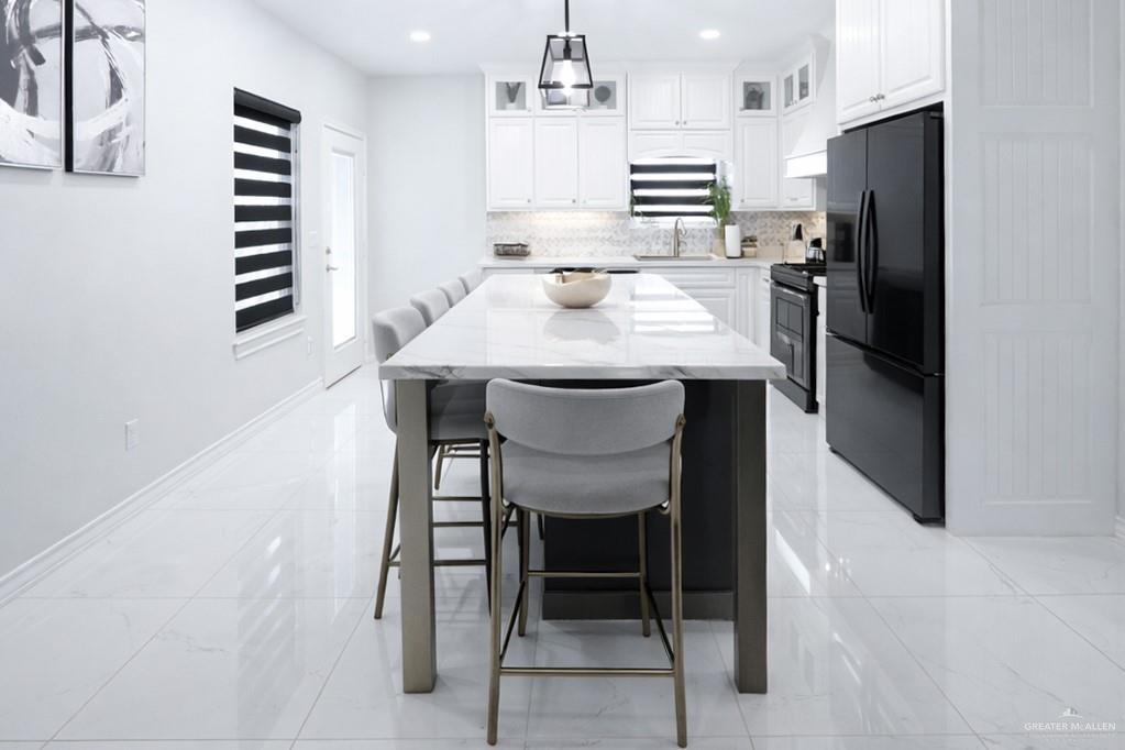 325 Dawn Street Rio Grande City, TX 78582 - Photo 5 of 17 a kitchen with refrigerator and chairs