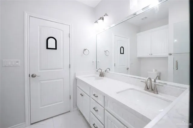 a bathroom with double vanity sink and a mirror