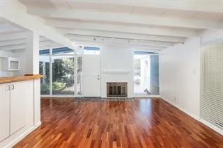 a view of a livingroom with wooden floor and a fireplace