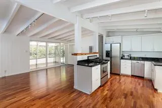 a kitchen with granite countertop a stove and wooden floor