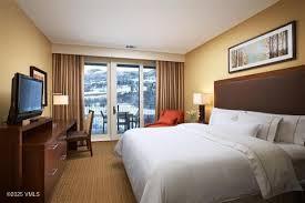 218 Riverfront Lane, Unit 2P203A/B Avon, CO 81620 - Photo 2 of 9 a bedroom with a bed and a flat tv screen on dresser