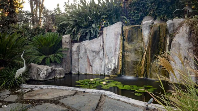 a view of a street with potted plants and large trees