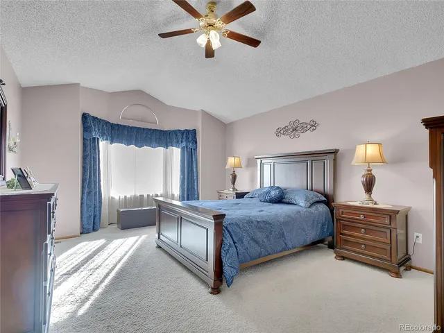 a spacious bedroom with a bed and a chandelier