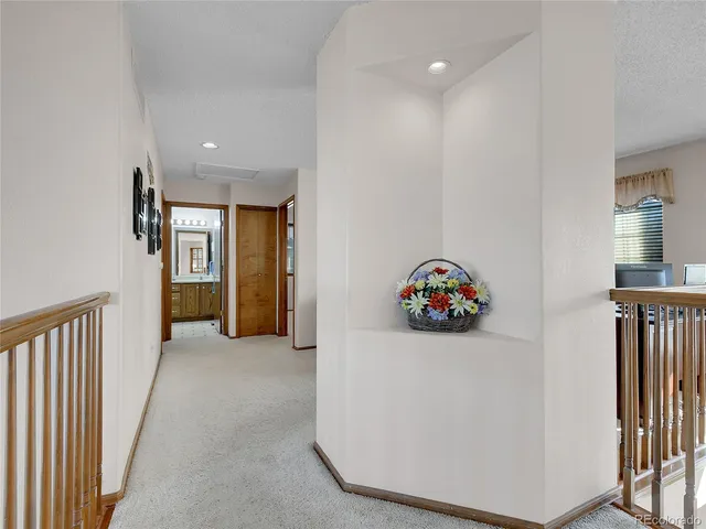 a view of hallway with stairs and a workspace