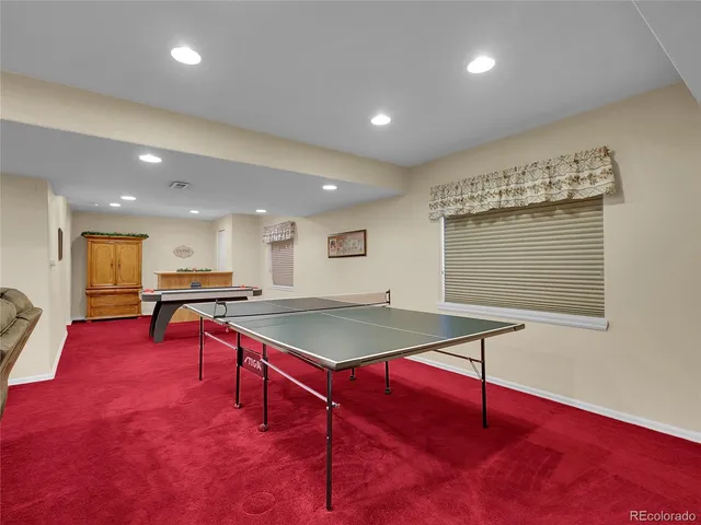 a room with furniture pool table and windows