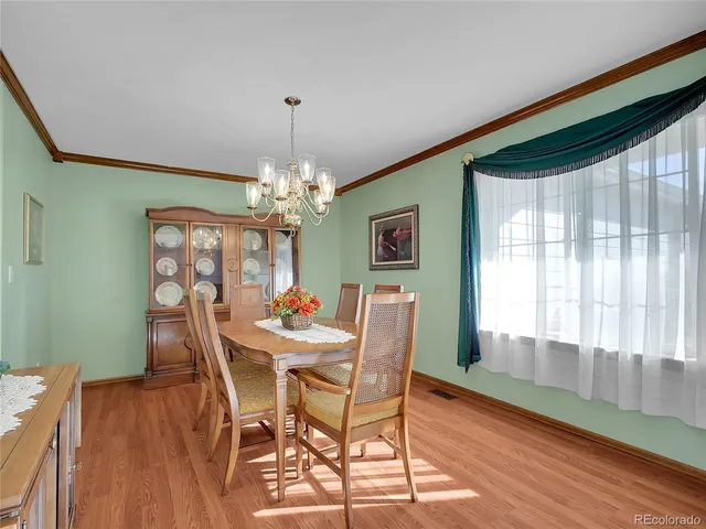 a dining room with furniture a chandelier and wooden floor