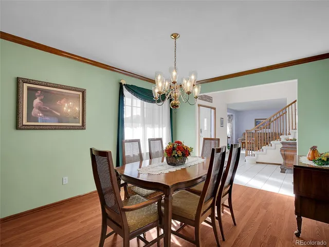 a view of a dining room with furniture a chandelier and wooden floor