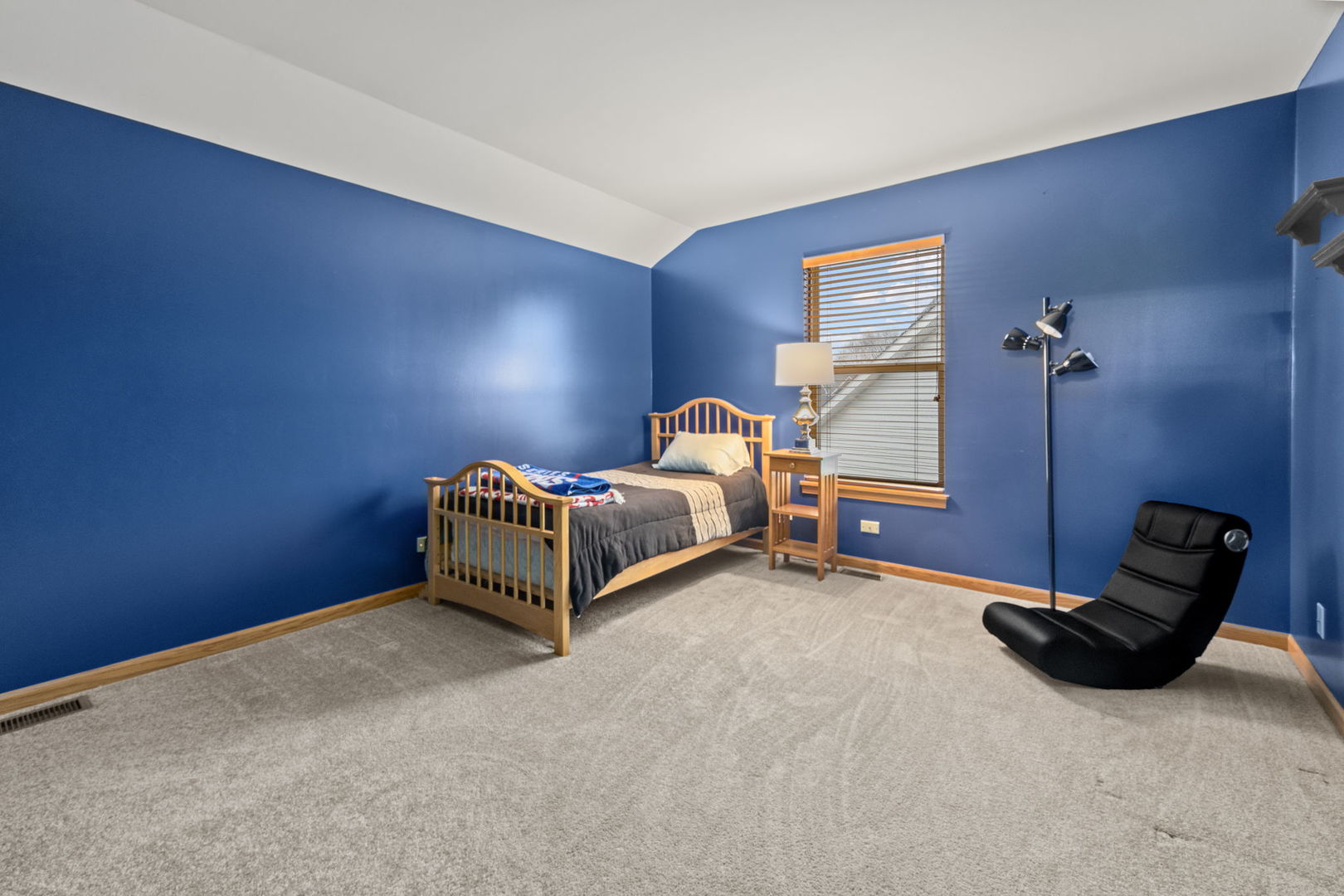 33 Forestview Lane Aurora, IL 60502 - Photo 19 of 27 a bedroom with bed and a chair