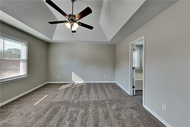 an empty room with fan and windows