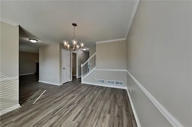 a view of a room with wooden floor staircase and a kitchen