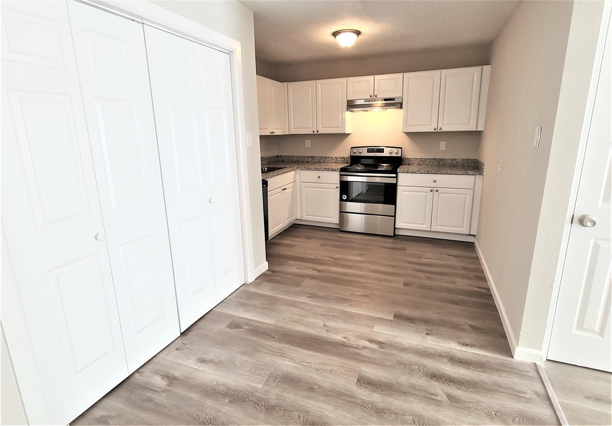 10329 Wicklowe Street Houston, TX 77016 - Photo 3 of 10 a kitchen with granite countertop white cabinets and white appliances