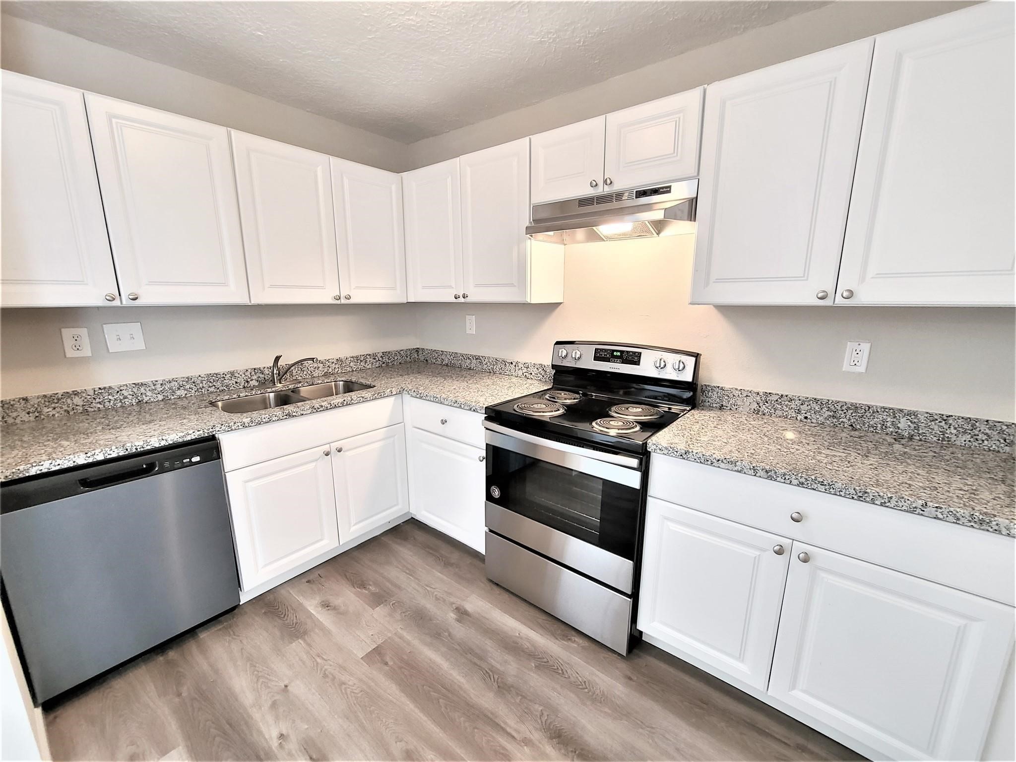 10329 Wicklowe Street Houston, TX 77016 - Photo 4 of 10 a kitchen with granite countertop white cabinets and white appliances