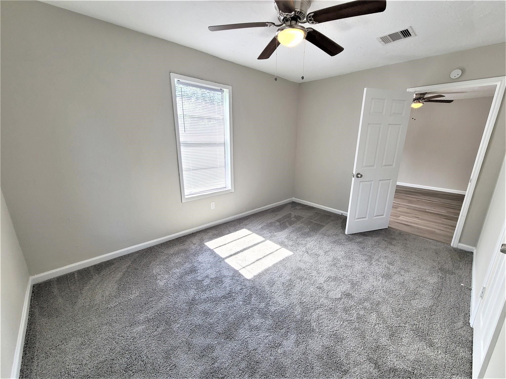 10329 Wicklowe Street Houston, TX 77016 - Photo 6 of 10 an empty room with windows and fan