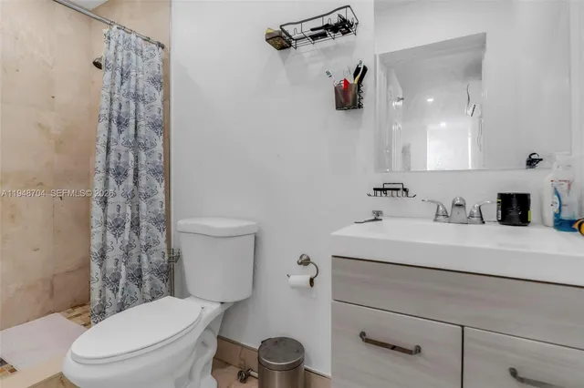 a bathroom with a sink a toilet and shower curtain