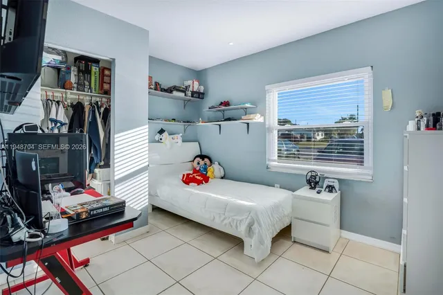 a bedroom with baby bed and a window