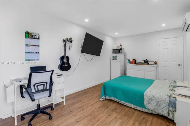 a living room with a bed furniture and a flat screen tv