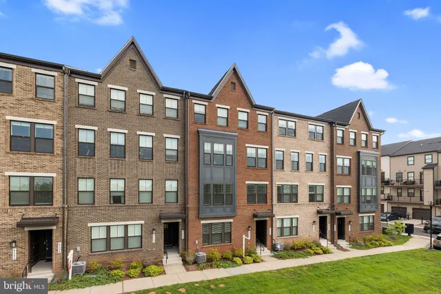 a front view of a residential apartment building with a yard