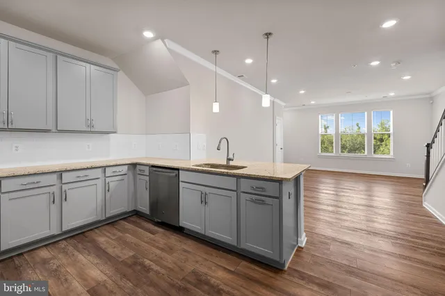 a kitchen with a sink cabinets wooden floor and a window