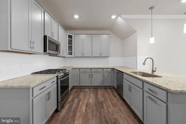 a kitchen with stainless steel appliances granite countertop a sink stove and cabinets