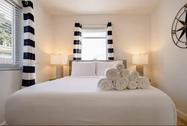 a large bed sitting in a bedroom next to a window and a walk in closet