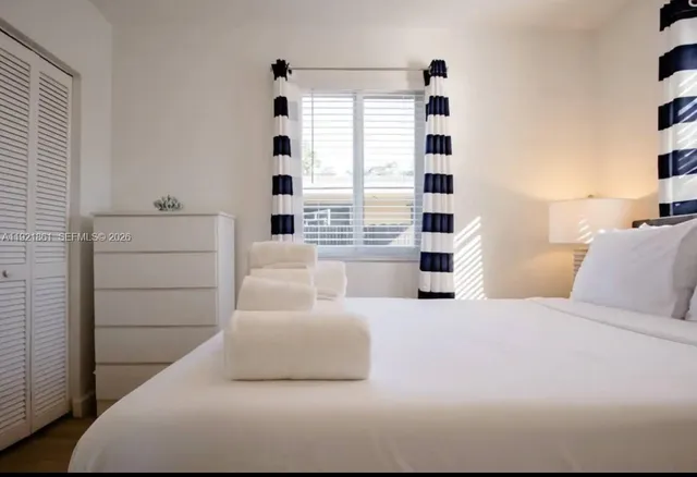 a bedroom with furniture and a large window