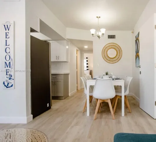 a view of a dining room with furniture and a chandelier