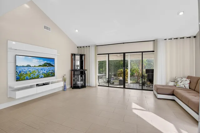 a living room with furniture large window and flat screen tv