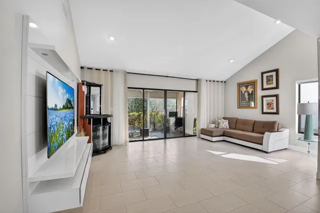 a living room with furniture large window and flat screen tv