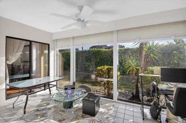 a living room with patio furniture and a potted plant