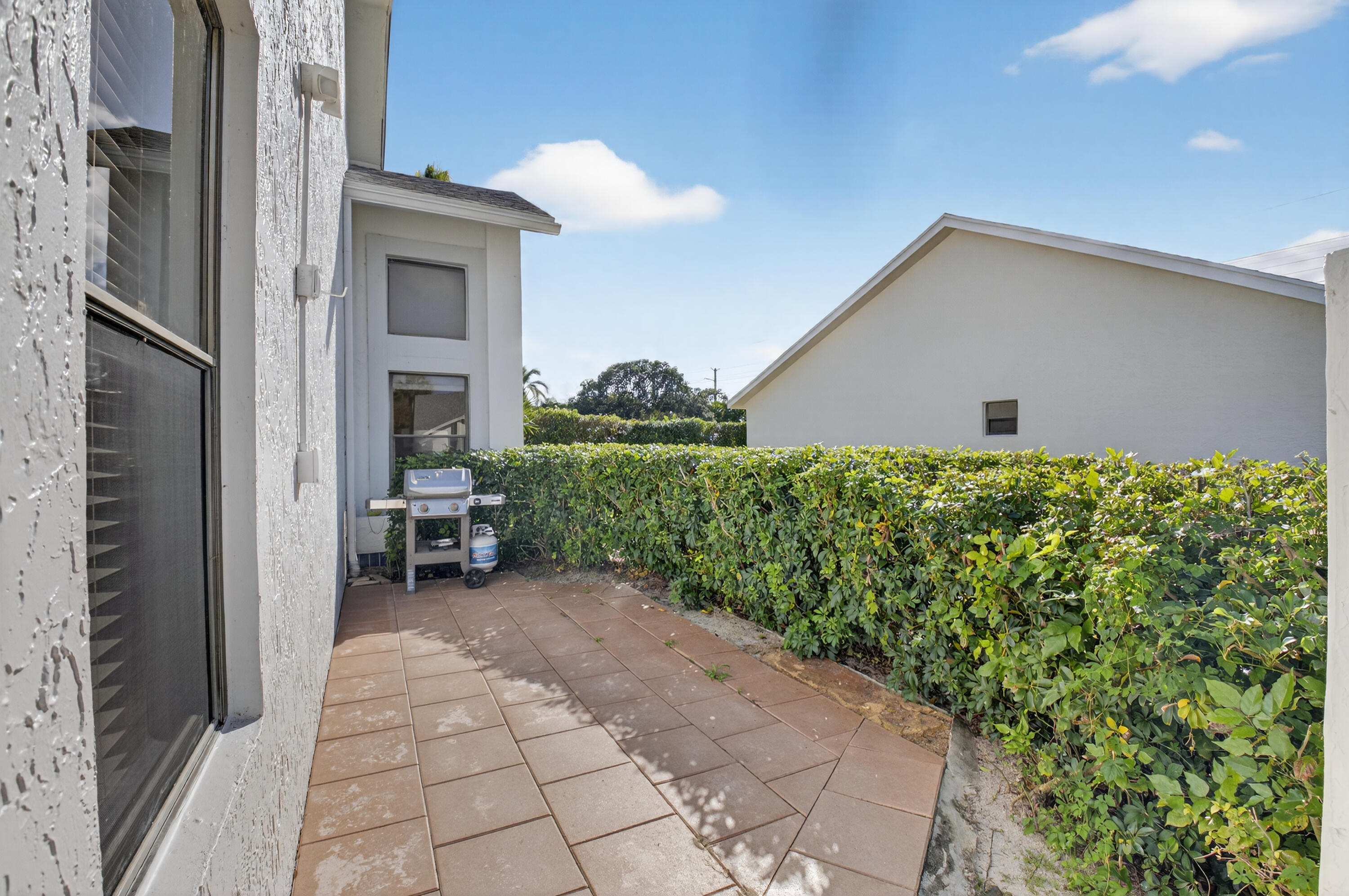 10980 Hidden Lake Place Boca Raton, FL 33498 - Photo 25 of 44 a view of a house with a bench in a patio