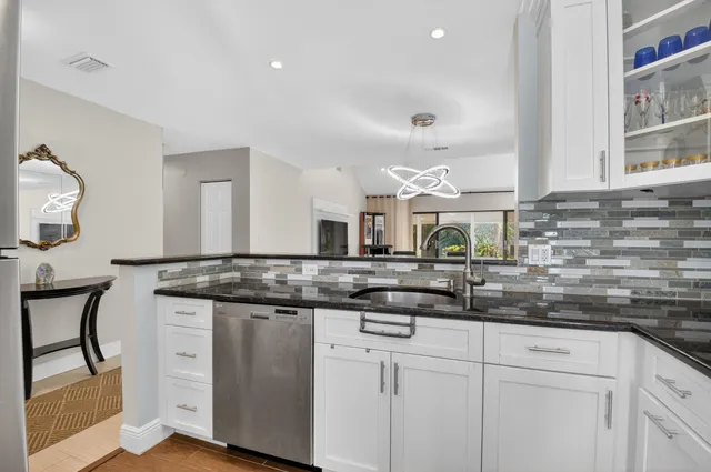 a kitchen with stainless steel appliances granite countertop a sink and cabinets