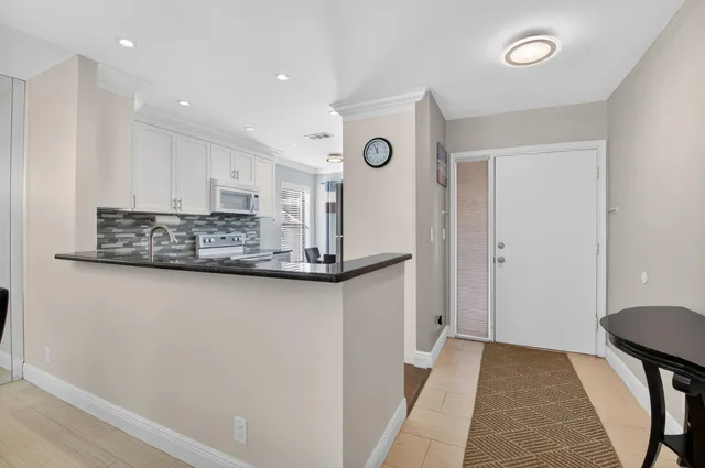 a kitchen with stainless steel appliances granite countertop a stove a sink and a refrigerator with wooden floor