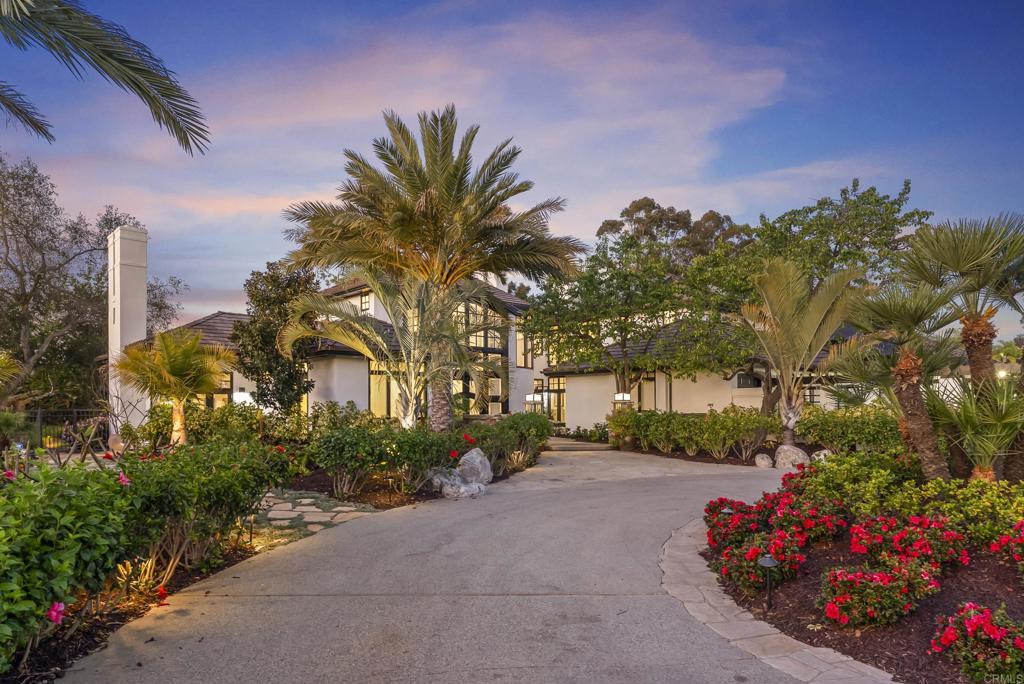 7891 Muirfield Way Rancho Santa Fe, CA 92067 - Photo 20 of 26 a front view of a house with a yard and fountain in middle of the road