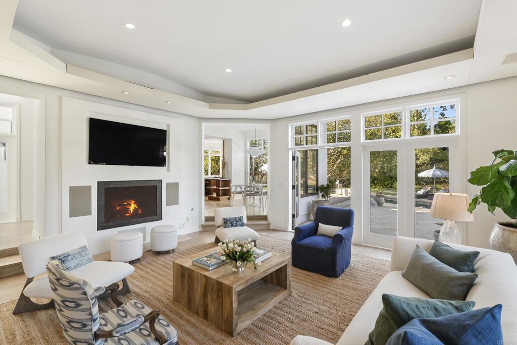 7891 Muirfield Way Rancho Santa Fe, CA 92067 - Photo 6 of 26 a living room with furniture a fireplace and a flat screen tv