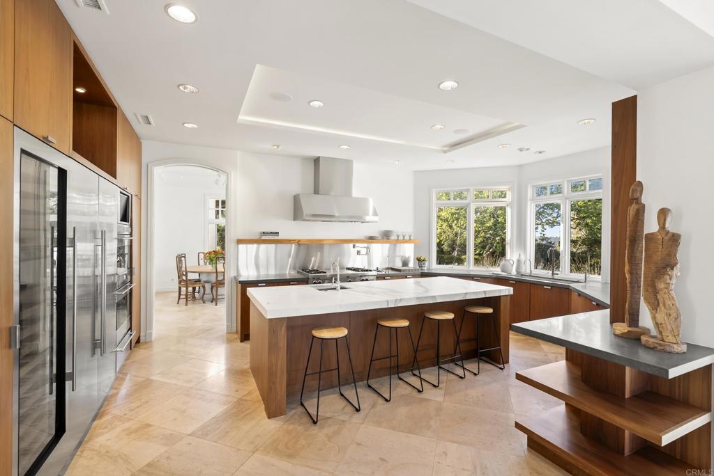 7891 Muirfield Way Rancho Santa Fe, CA 92067 - Photo 7 of 26 a kitchen with stainless steel appliances granite countertop a stove and a refrigerator