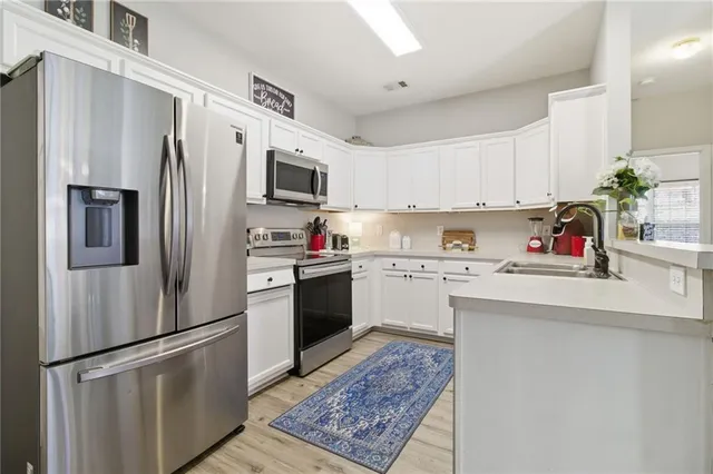 a kitchen with a refrigerator sink and white cabinets