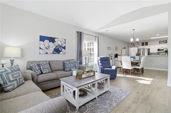 a living room with furniture and view of kitchen