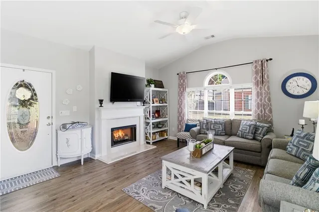 a living room with furniture a flat screen tv and a fireplace
