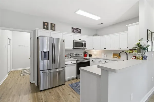 a kitchen with stainless steel appliances a refrigerator stove microwave and cabinets