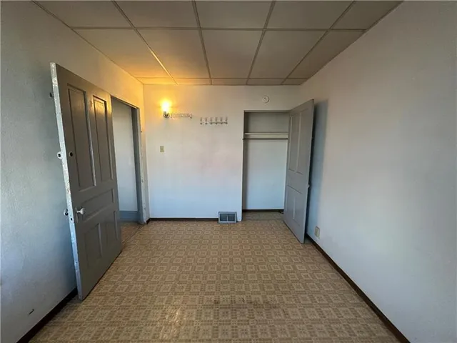 a view of an empty room with a fireplace and a window