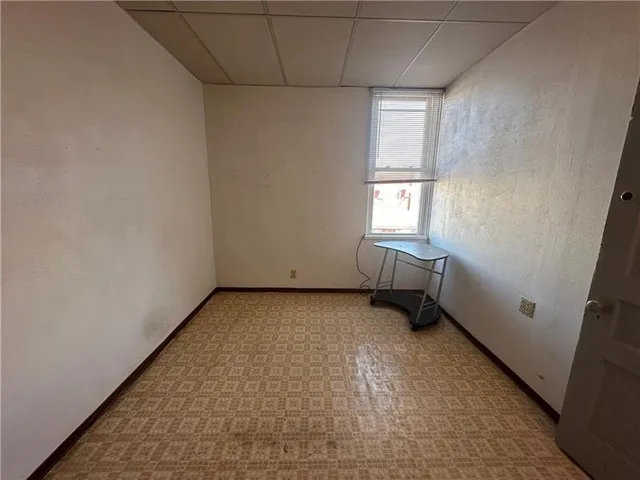 a view of an empty room with a fireplace and a window