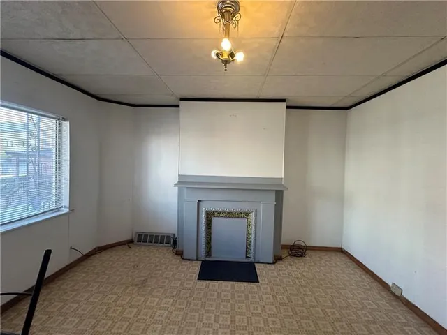 a view of an empty room with a fireplace and a window