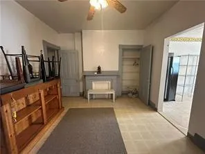 wooden floor in an empty room with a cabinet and a chandelier