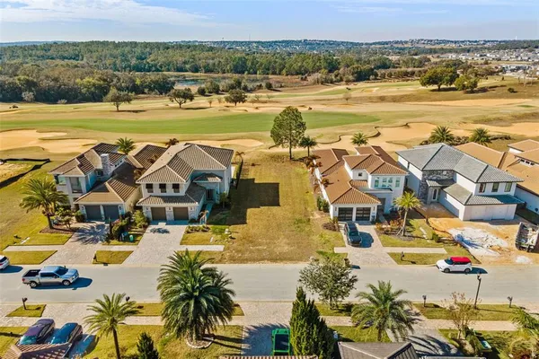 an aerial view of residential houses with outdoor space and ocean view