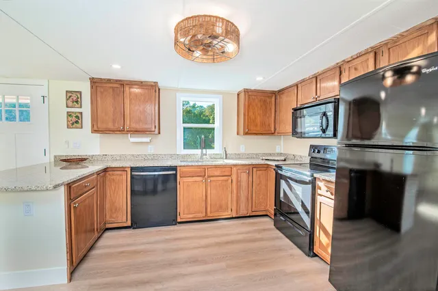 a kitchen with stainless steel appliances granite countertop a stove top oven a sink and a microwave