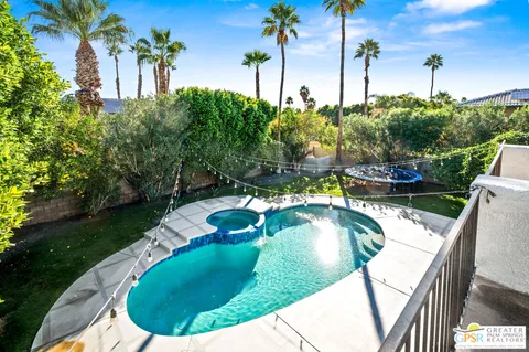 a view of a swimming pool with a yard and plants