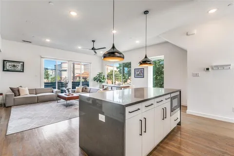 a kitchen with stainless steel appliances granite countertop a kitchen island a stove a table and chairs