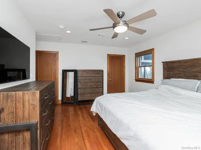 a spacious bedroom with a bed and a flat screen tv