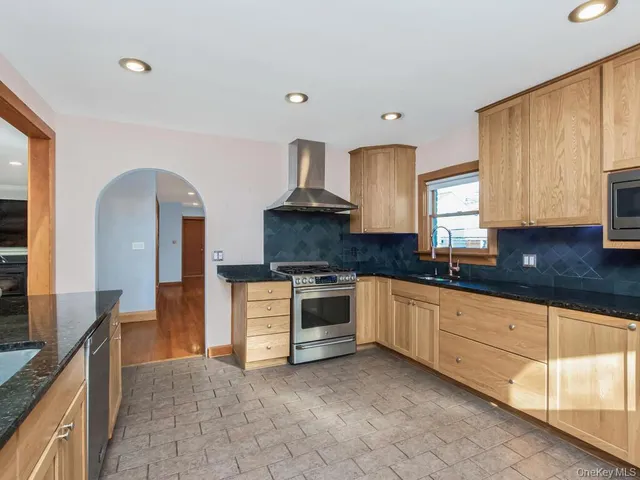 a kitchen with granite countertop a sink stainless steel appliances and cabinets