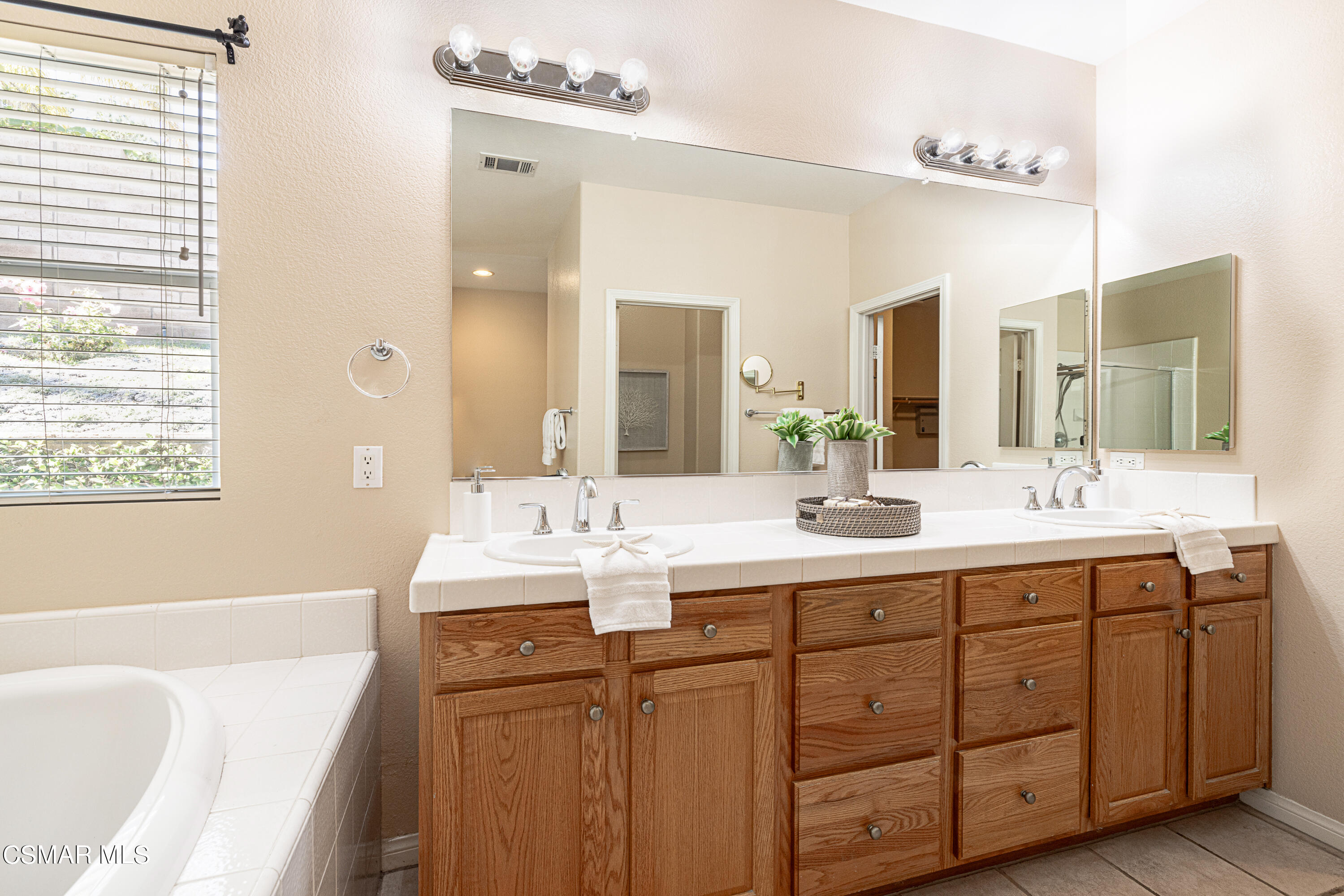 931 North Wood Ranch Parkway Simi Valley, CA 93065 - Photo 21 of 33 a bathroom with a sink double vanity granite tub shower and a mirror